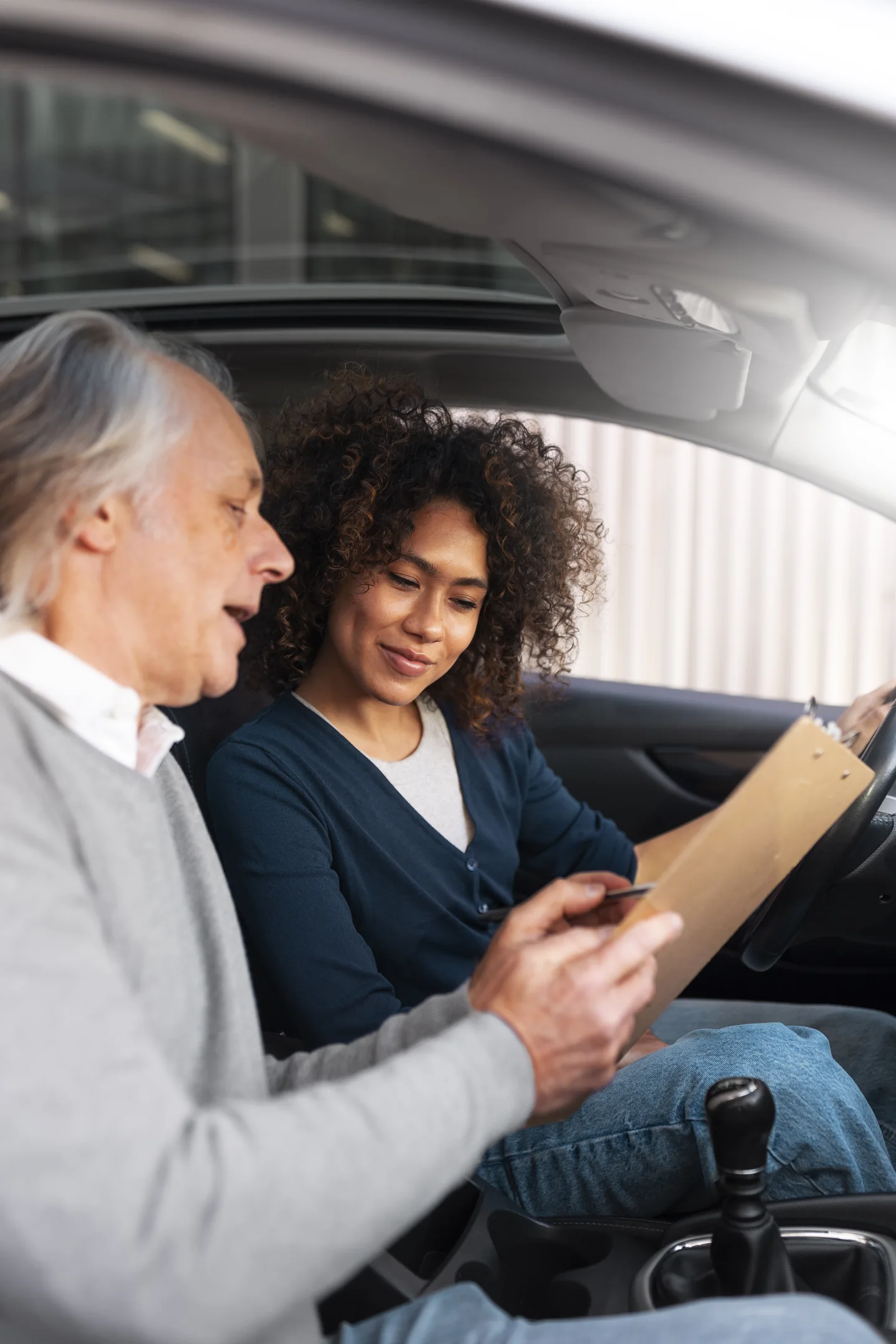 Dos mujeres revisan documentos en los asientos delanteros de un coche